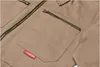 Close-up of a beige garment with a red logo tag. Náhled obrázku produktu