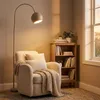 A cozy reading nook with a chair, floor lamp, and bookshelf. Produktbild-Vorschau