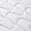 A close-up, detailed view of a white quilted blanket or duvet. Produktbild-Vorschau