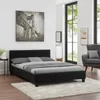 A bedroom scene featuring a black upholstered bed with gray bedding, a large abstract painting of a bridge on the wall, and a window with greenery visible outside. Produktbild-Vorschau