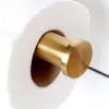 A close-up of a gold-colored toilet paper holder with a roll of toilet paper on it. Produktbild-Vorschau