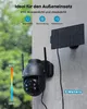 A security camera with a solar panel mounted on a wall during a rainy day. Produktbild-Vorschau