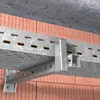 A close-up view of a metal cable tray system mounted on a brick wall. Náhľad obrázku produktu