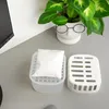 A dehumidifier packet and its container sit on a grey desk next to a potted plant. Voir les images du produit