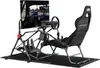 A racing simulator cockpit with a chair, steering wheel, pedals, and monitor stand. Podgląd zdjęcia produktu