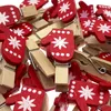 A pile of red and white mitten-shaped wooden clothespins. Produktbild-Vorschau