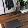 A close-up view of a wooden desk with a laptop, a plant, and framed artwork. Voir les images du produit
