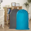 Two large laundry bags, one gray and one blue, are placed on a wooden floor in front of a wooden shelf unit. Produktbild-Vorschau