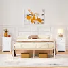 A bedroom scene featuring a white metal bed frame with bedding, two white nightstands, and abstract wall art. Produktbild-Vorschau