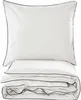 A neatly folded set of white bedding with navy trim, including a pillow and a duvet or comforter. Produktbild-Vorschau