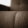 A close-up shot of the textured fabric of a sofa, showing a seam running vertically down the middle. Náhled obrázku produktu