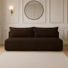 A dark brown boucle sofa is shown in a well-lit room with white paneled walls and a round mirror above it. A light-colored rug is in the foreground. Voir les images du produit