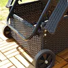 Close-up view of the wheels and woven texture of a black lounge chair on a wooden deck. Anteprima dell’immagine prodotto