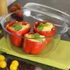 Stuffed red bell peppers in a glass baking dish, with cherry tomatoes in the foreground. Náhľad obrázku produktu