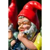 A close-up of a garden gnome figurine playing a flute, with other gnomes blurred in the background. Produktbild-Vorschau