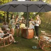 A group of people enjoying a gathering outdoors under a large umbrella. Náhled obrázku produktu