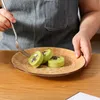 A person is holding a fork over a plate with three green swiss rolls. Náhled obrázku produktu