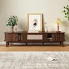 A wooden TV stand with decorative items and a rug in a living room setting. Produktbild-Vorschau