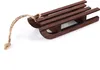 A small wooden sled with a rope attached, lying on a white surface. Produktbild-Vorschau