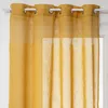 A close-up view of a yellow curtain hanging from a curtain rod. Produktbild-Vorschau