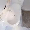 A top-down view of a white bathtub with a chrome faucet, set against a marble-tiled bathroom floor. Produktbild-Vorschau
