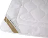 A close-up view of a white quilted blanket with a label indicating 'ALPAKA' and 'SENNA home'. Produktbild-Vorschau