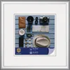 A flat lay of travel items arranged on a blue wooden surface, framed by a silver mat and frame. Produktbild-Vorschau
