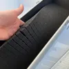 A hand is shown holding a piece of black foam padding inside a silver aluminum case. Produktbild-Vorschau
