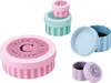 A collection of small, decorative round boxes with striped patterns and branding. Anteprima dell’immagine prodotto