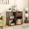 A wooden cube shelf with a drawer and open compartments, decorated with books, a radio, and a plant, placed in a living room setting next to a green sofa. Podgląd zdjęcia produktu