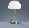 A modern LED table lamp with a brushed nickel finish and a white dome-shaped shade, set against a plain gray background. Produktbild-Vorschau