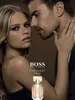 A man and a woman are shown in a close, intimate pose, with a bottle of perfume in the foreground. Anteprima dell’immagine prodotto