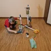 A young boy is playing with a cleaning toy set on a wooden floor. Anteprima dell’immagine prodotto