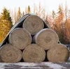 Hay bales stacked and covered with a tarp in a rural setting. Produktbild-Vorschau