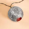 A single, decorative spherical light fixture with intricate cutouts, resting on a plain, light-colored surface. Produktbild-Vorschau