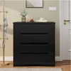 A black dresser with four drawers is shown in a room, next to a coat rack and a door. Náhled obrázku produktu