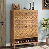 A wooden shoe cabinet with two drawers and a shelf for shoes, placed in a room with a door and a plant. Podgląd zdjęcia produktu