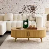 A living room scene with a couch, coffee table, and rug. Produktbild-Vorschau