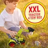 A young boy playing with a toy tractor in the grass. Anteprima dell’immagine prodotto