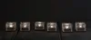 Six ice cube shaped candle holders with lit candles inside, arranged in a row on a dark surface. Podgląd zdjęcia produktu