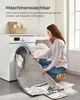 A woman is putting a blanket into a washing machine. Produktbild-Vorschau