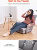 A woman is sitting in a floor chair, listening to music with headphones. The chair is in a living room setting with a small side table and a plant. Voir les images du produit