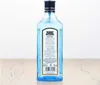 A bottle of Bombay Sapphire London Dry Gin is shown from the back, standing on a wooden surface. Produktbild-Vorschau