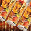 Three cylindrical stainless steel grill baskets filled with food, such as shrimp, vegetables, and possibly chicken, are arranged diagonally against a blurred background of grill grates and flames. Náhled obrázku produktu