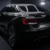 The rear of a black car is shown in a dark studio setting. Náhled obrázku produktu