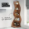 A corner shelf unit filled with various items, placed in a room setting near a window. Produktbild-Vorschau