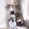 A decorated corner with a snowman, ice skates, and candles on a shelf. Produktbild-Vorschau