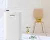 A white dehumidifier is shown next to a chair with a bowl of grapes on it, in a room with white walls. Anteprima dell’immagine prodotto
