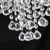 A close-up view of a crystal chandelier with many hanging faceted crystal teardrops and spheres against a black background. Produktbild-Vorschau