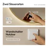 A split image showing two ways to control a mirror's LED light: one with touch controls on the mirror itself, and another showing a hand interacting with a wall switch. Produktbild-Vorschau